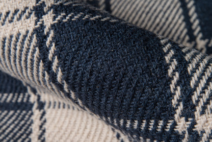 Close-up of navy and cream knitted plaid rug with a chunky wool texture, 2' x 3'.