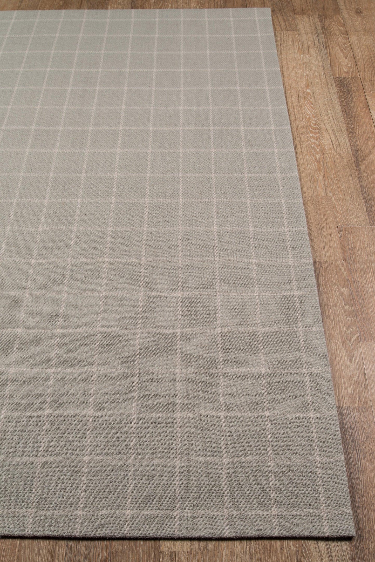Gray flat-weave area rug with a white grid pattern, rectangular, modern geometric style for living room on wood floor.