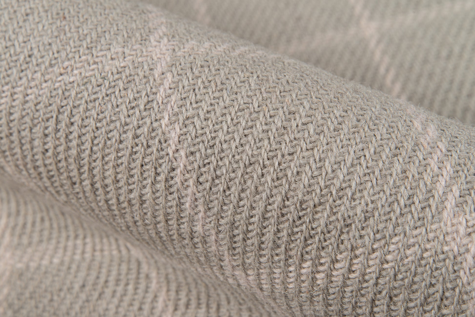 Close-up of soft gray-beige knitted fabric with visible ribbed texture.