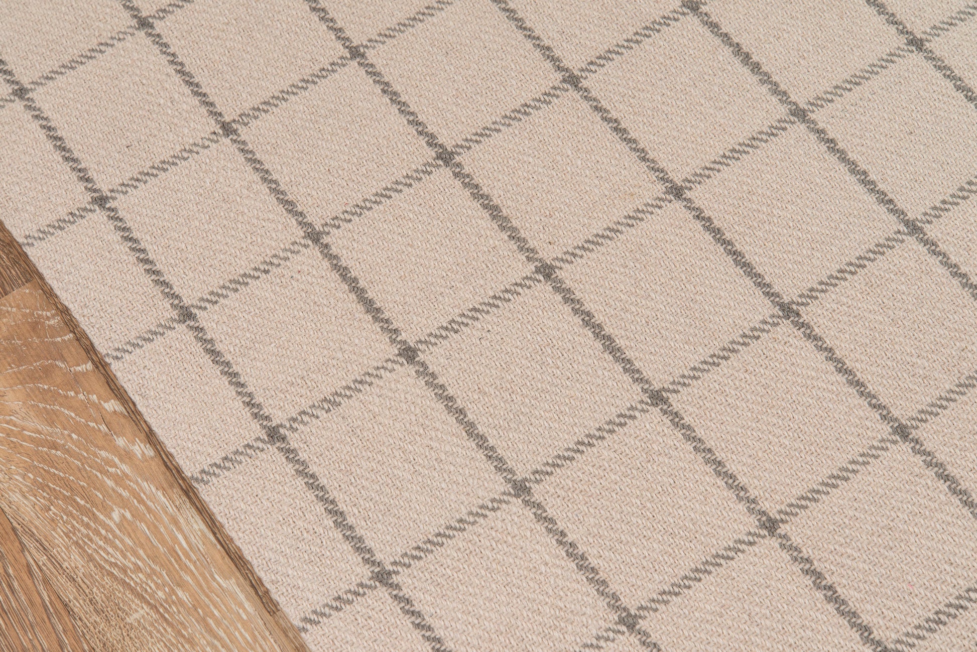 Beige woven runner rug (2'3" x 8') with gray grid pattern and square motif, laid over light wood floor.