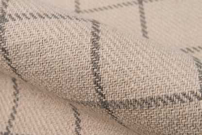 Beige woven wool blanket with gray plaid lines, textured fabric close-up.