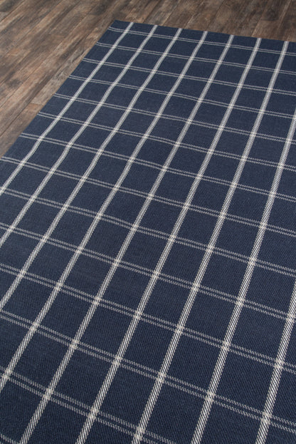 Rectangular navy blue rug with white grid pattern, woven fabric on wood floor.