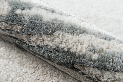 Soft grey shag rug with dense, fluffy fibers in layered gray tones & plush, modern throw rug.
