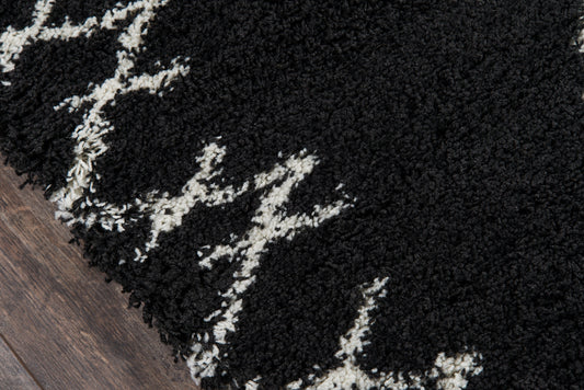 Black shag rug with white geometric line pattern, plush high-pile texture on dark wood floor.