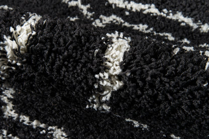 Close-up of black & white shag rug with high-pile, chunky fibers & abstract pattern.