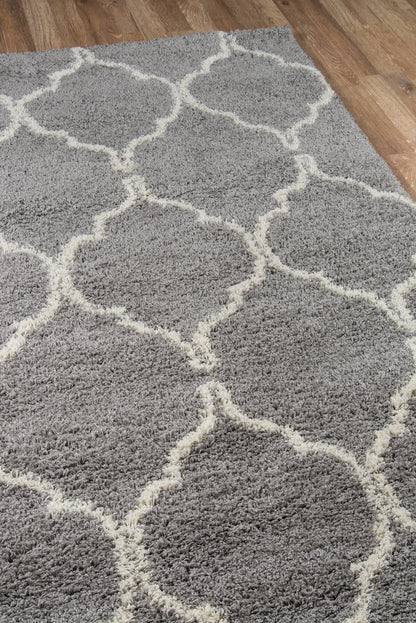 Gray shag area rug with cream lattice trellis pattern on hardwood floor.