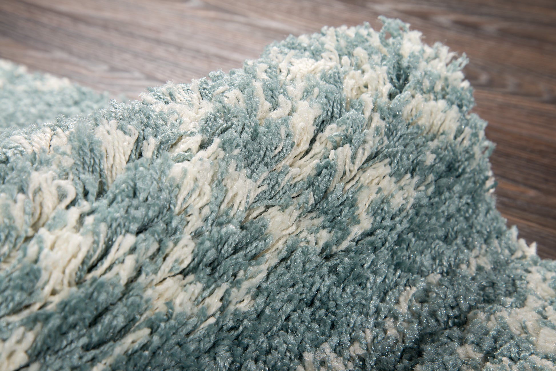 Shag rug in teal and cream with long fluffy pile; soft textured, modern decor for living rooms.