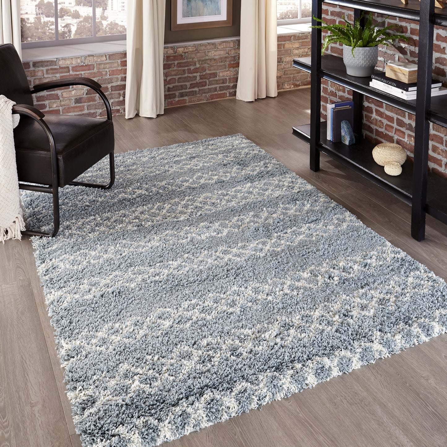 Rectangular blue-gray shag rug with plush high-pile in a modern living room with brick walls.