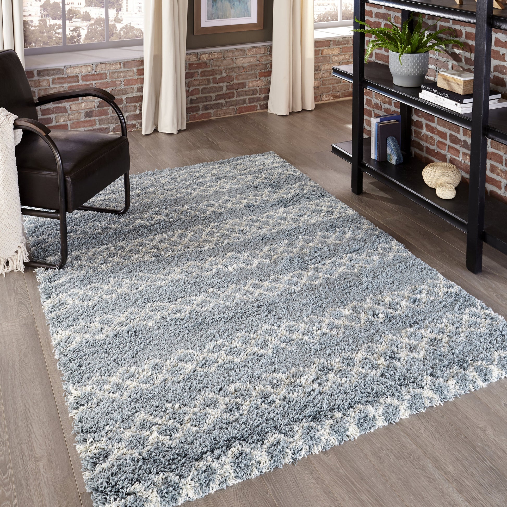 Rectangular blue-gray shag rug with plush high-pile in a modern living room with brick walls.