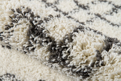 Cream and gray high-pile shag rug with plush fibers in an abstract striped pattern.