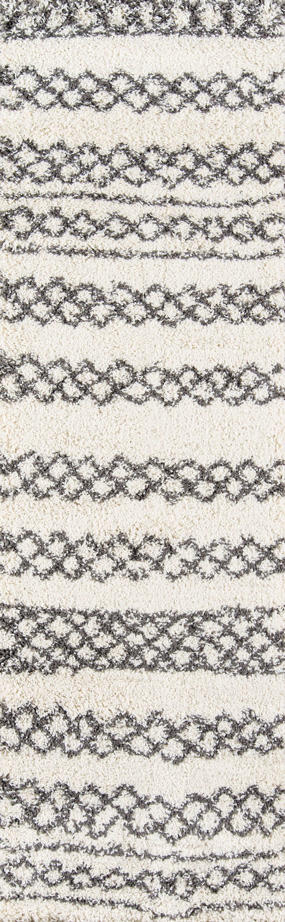 Beige shag rug with gray interlocking diamond chain stripes and soft textured pile.