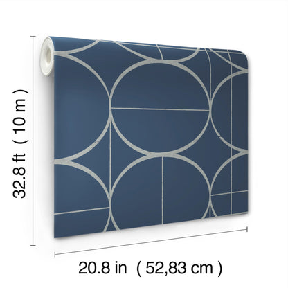 Blue wallpaper with circular geometric sun-circle motif in white and silver on a navy background; rolled left edge.