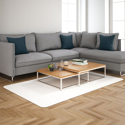 L-shaped light gray sectional sofa with teal pillows, two-tier wooden coffee table on a white rug in a bright living room.