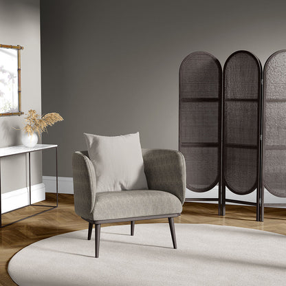 Taupe mid-century armchair with light cushion, dark legs, in grey room with a three-panel woven screen and circular beige rug