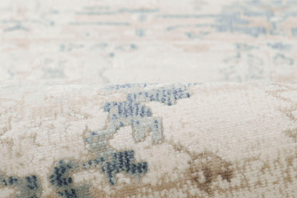 Cream rug with light blue geometric motifs and plush, textured pile; close-up detail.