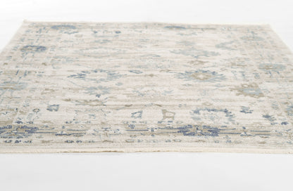 Cream & blue distressed floral area rug, rectangular with fringed border, low-pile weave.