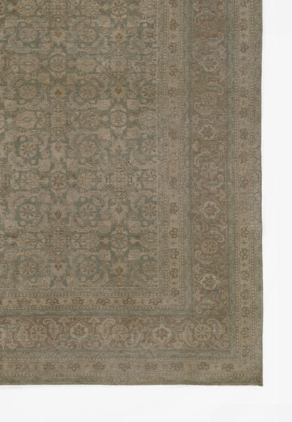 Rectangular vintage-style rug in muted blue-gray and beige with intricate floral border and patterned center.