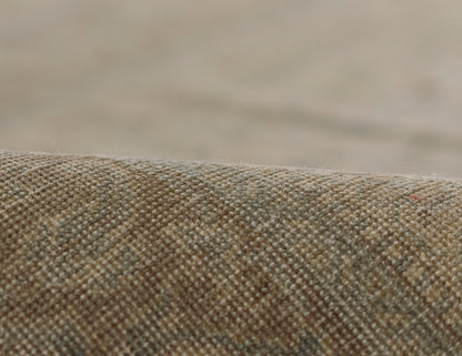 Close-up of brown beige tweed rug fabric with a tight woven texture and soft, nubby surface.