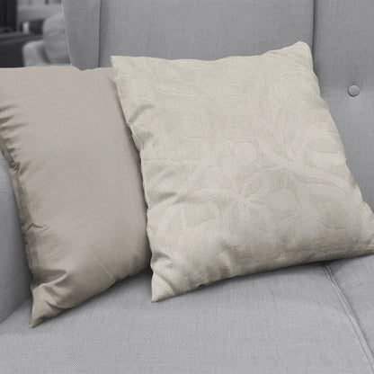 Beige velvet throw pillows on a gray sofa; plain tan pillow beside a light beige one with subtle floral pattern.