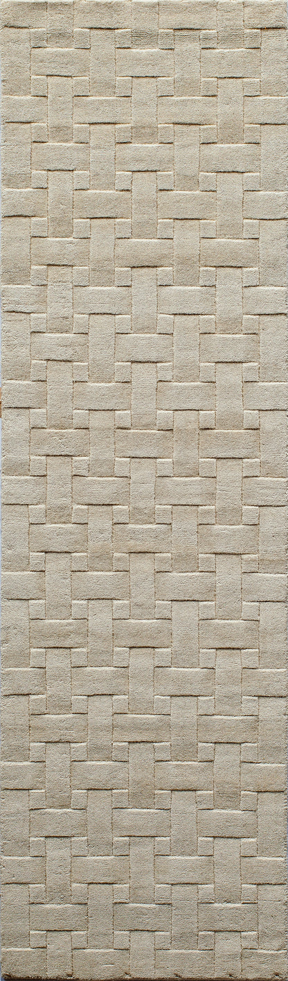 Beige basket-weave rug with interlocking rectangular strips; textured, neutral floor decor.