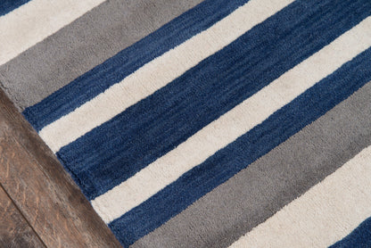 Rectangular plush area rug with navy, cream and gray stripes on a wooden floor.
