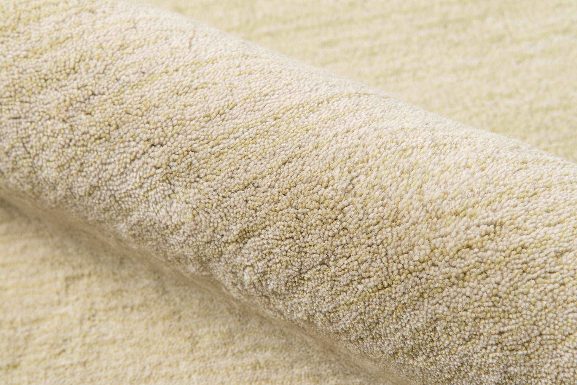 Cream-beige loop-pile fabric close-up; soft textured rug surface with warm neutral tones.