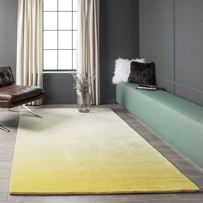 Gradient beige-to-yellow runner rug (2' x 8') in a modern living room with a brown leather chair, green bench and cushions.