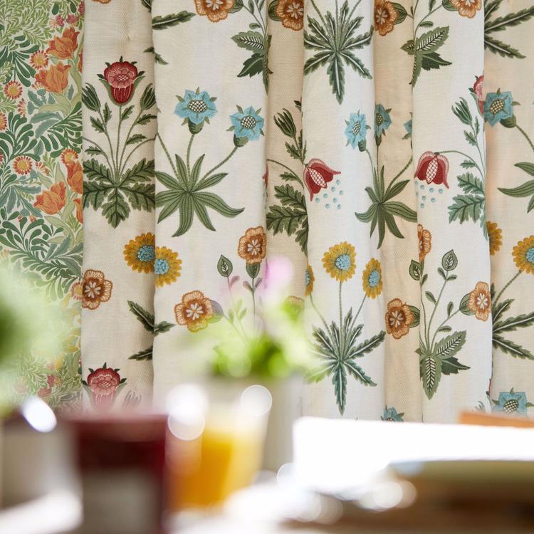 Luxury William Morris Daisy Embroidery Fabric in Cream Multi featuring colorful embroidered floral patterns on textured linen blend fabric. Elegant Morris & Co designer fabric inspired by the historic 1864 Daisy wallpaper, ideal for drapery panels, roman shades, decorative pillows, cottagecore interiors, English country homes, and luxury home décor sewing projects.