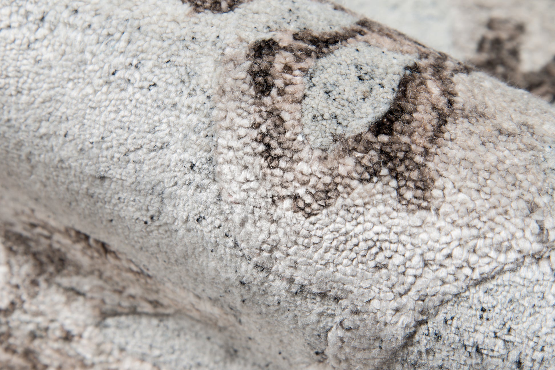 Light gray and ivory boucle rug with chunky textured pile and subtle charcoal pattern.