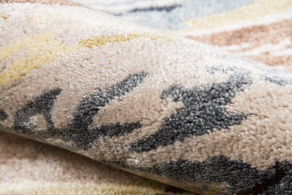 Close-up of a plush multicolor rug with beige base and dark gray abstract pattern, textured fluffy pile.