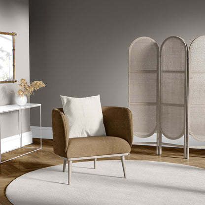 Brown mid-century armchair with cream cushion, white console table with dried pampas, and beige woven folding screen.