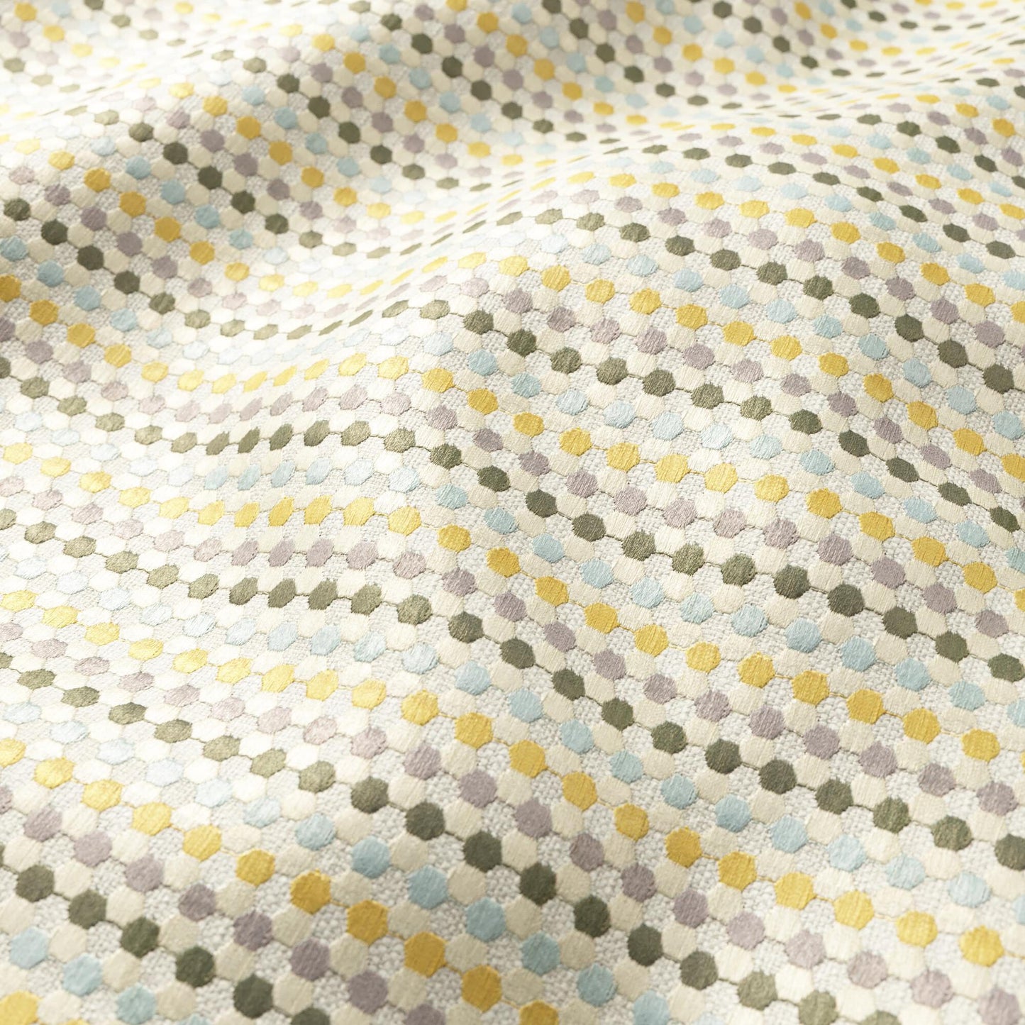Soft woven fabric with tiny pastel dots in yellow, blue, lavender and olive, forming a delicate geometric dotted pattern.