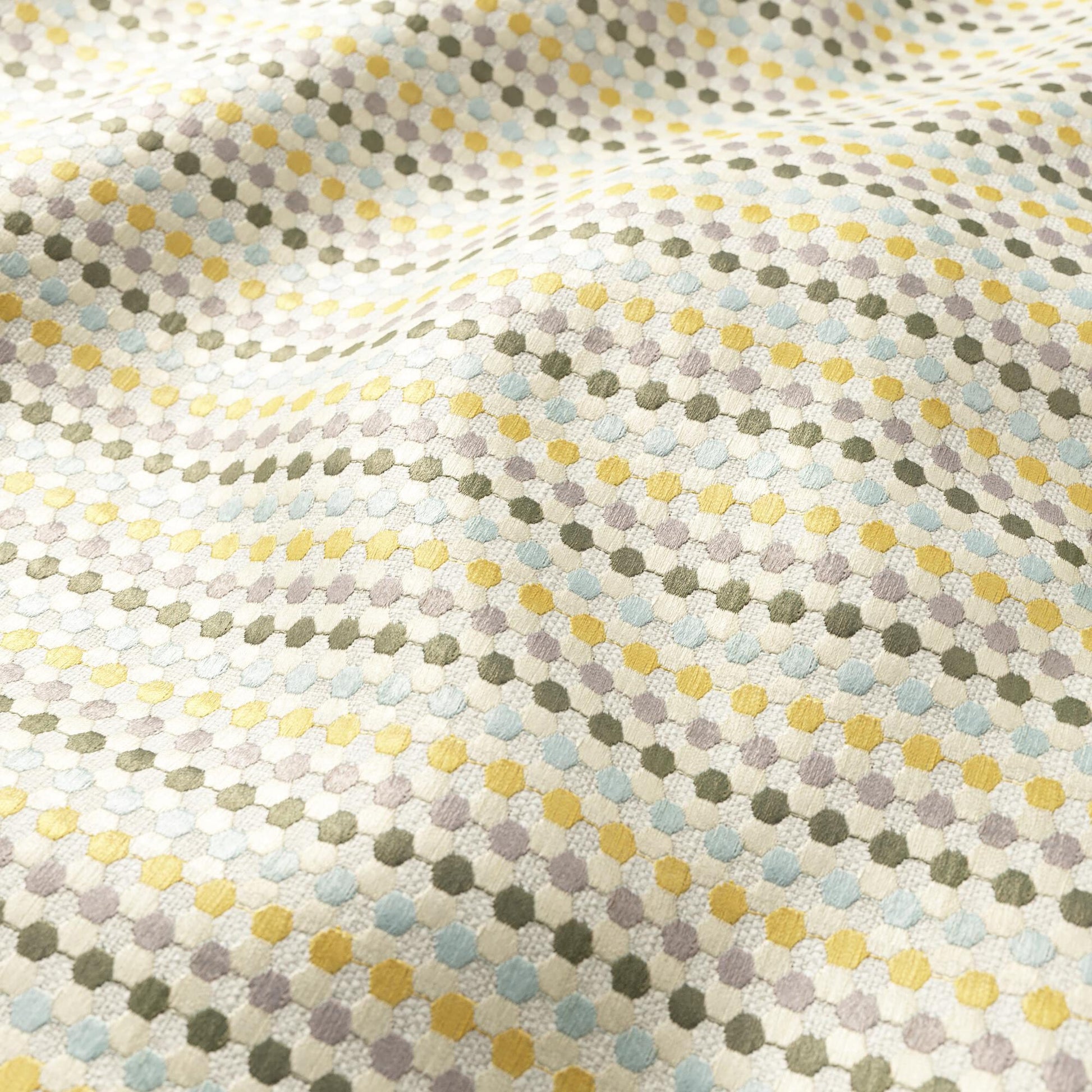 Soft woven fabric with tiny pastel dots in yellow, blue, lavender and olive, forming a delicate geometric dotted pattern.