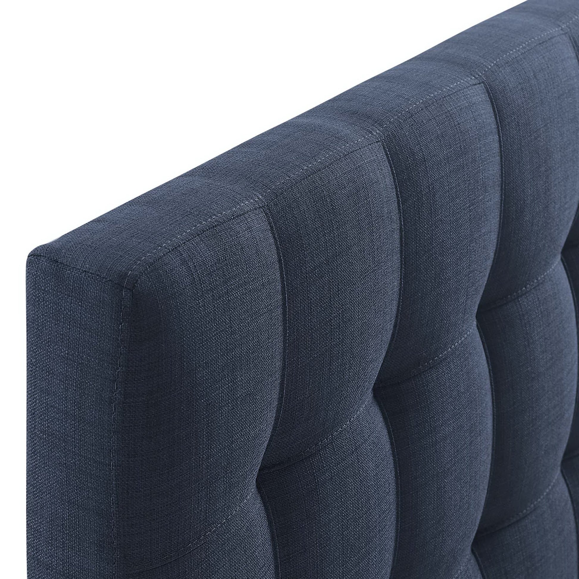 Navy blue tufted fabric upholstered headboard with square-panel design; close-up.