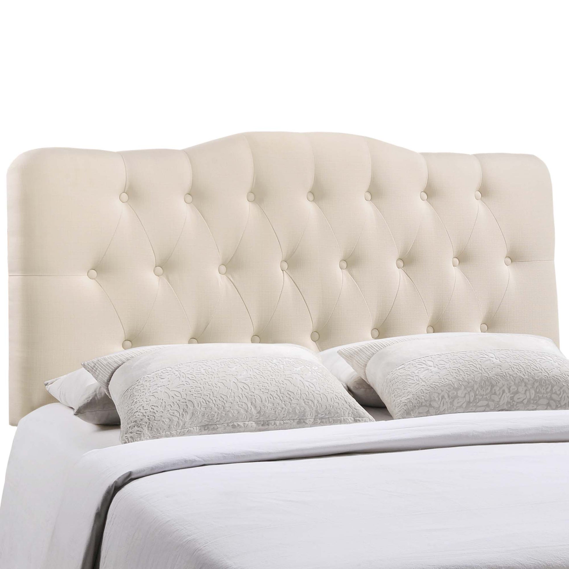 Ivory tufted upholstered full headboard with button accents, paired with white bedding.