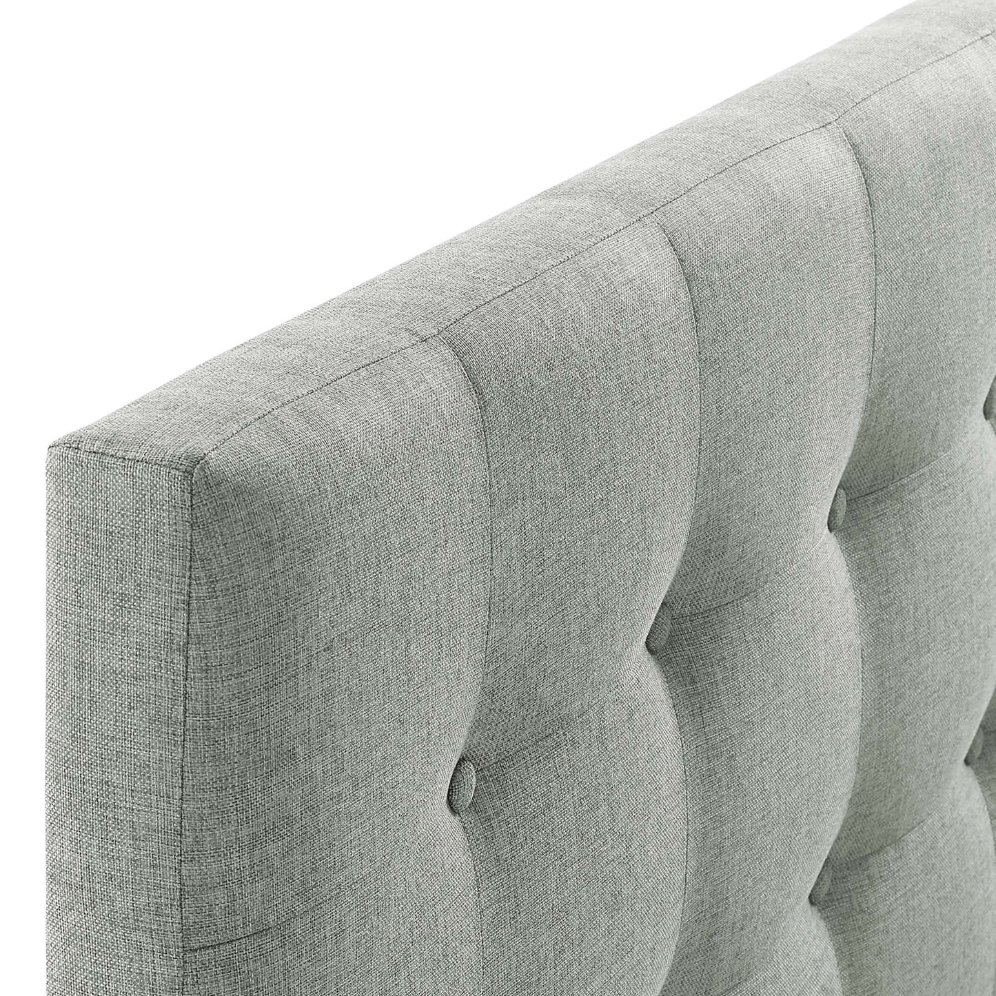 Light gray tufted fabric headboard with vertical channels and button tufting.