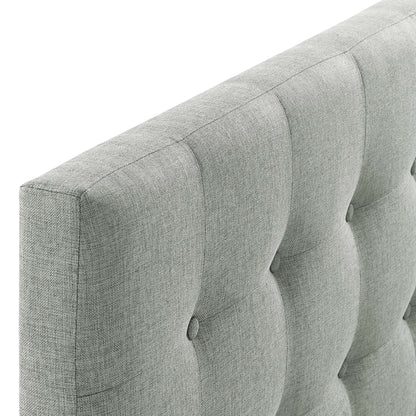 Light gray tufted fabric headboard with vertical channels and button tufting.