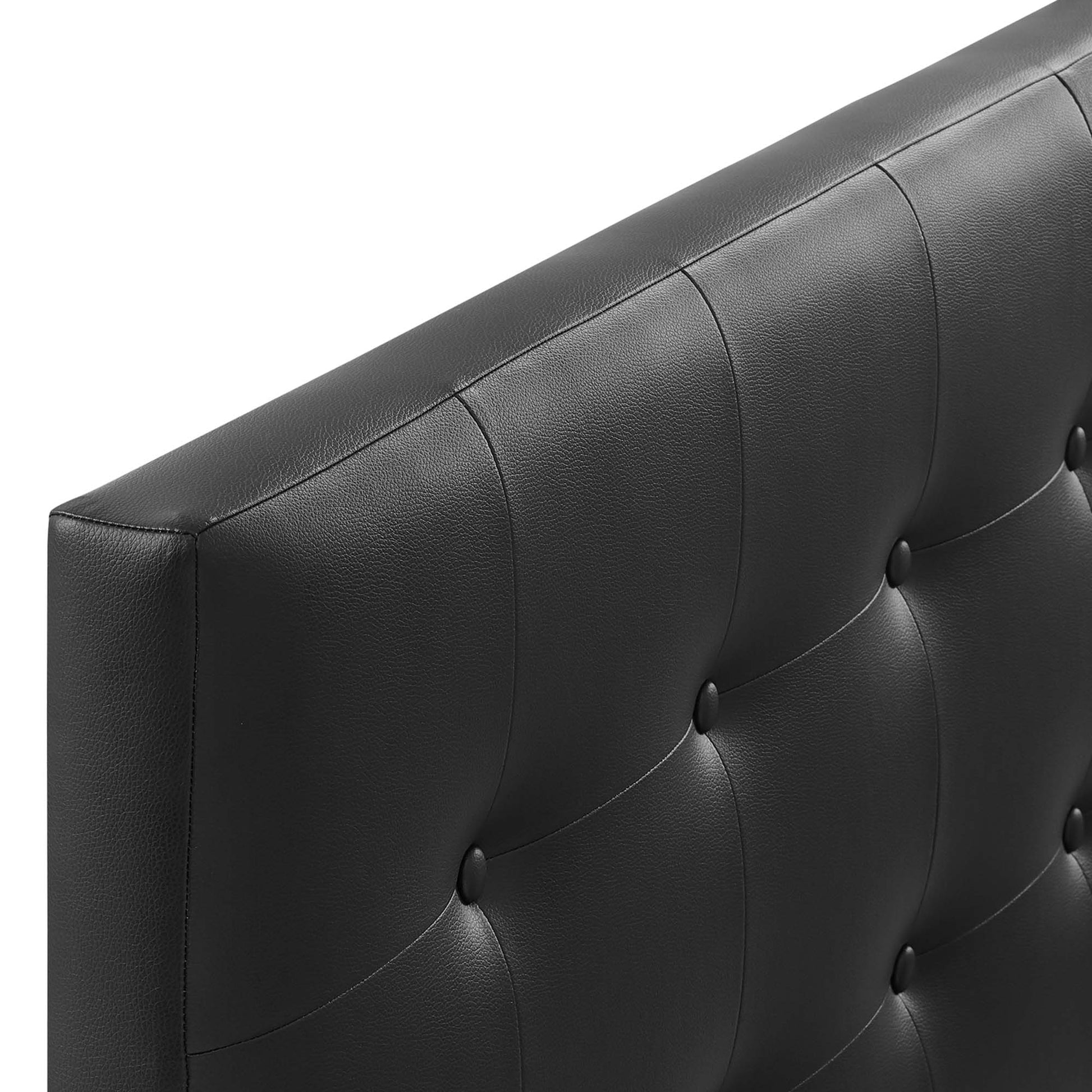 Close-up of black faux-leather tufted upholstery with button-tufted panels on a king headboard.