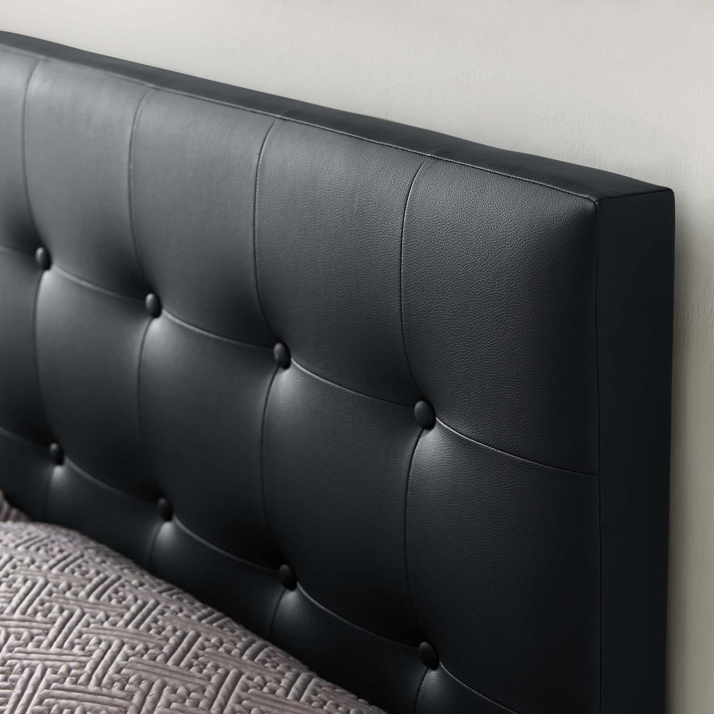 Black vinyl upholstered king headboard with square button-tufted panels for a modern bedroom.