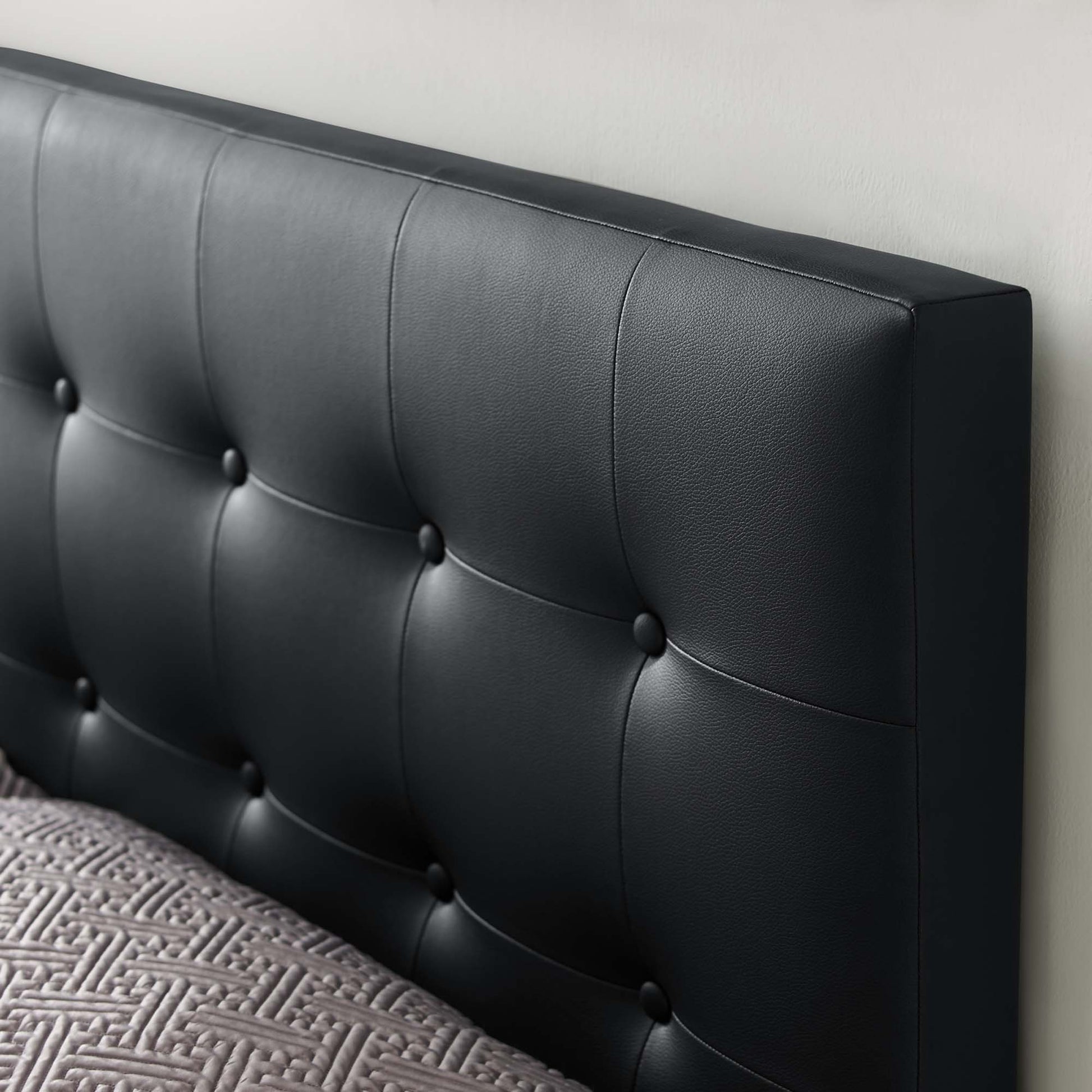Black vinyl upholstered king headboard with square button-tufted panels for a modern bedroom.