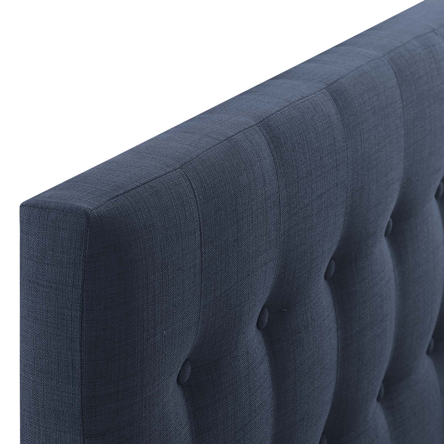 Navy blue tufted fabric headboard with vertical channels & button tufts; close-up of an upholstered twin headboard.