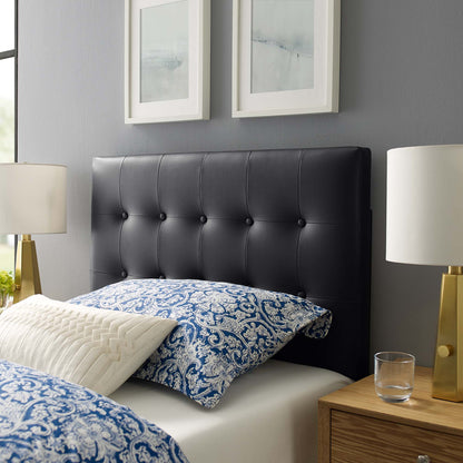 Black tufted headboard with blue damask bedding, white quilted pillow, and gold-lamped nightstands with framed art