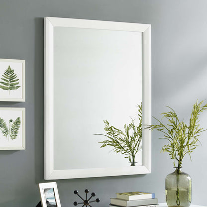 White rectangular wall mirror with beveled frame on gray wall; modern minimalist style with greenery vase nearby.