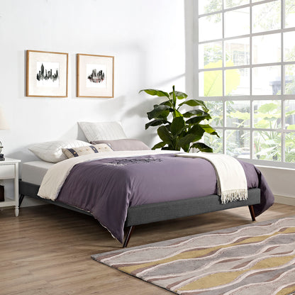 Gray upholstered platform bed with lavender duvet and white throw in a bright modern bedroom; large window, and plant.