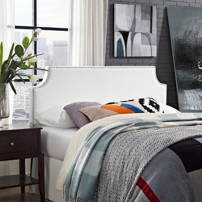White upholstered vinyl queen headboard with curved nailhead trim; gray bedding and colorful pillows.