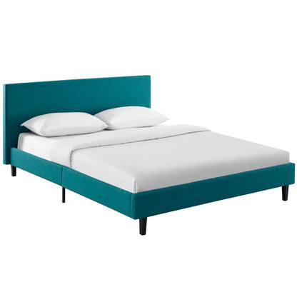 Teal upholstered platform bed with tall headboard, white bedding and pillows, modern mid-century style, dark legs.