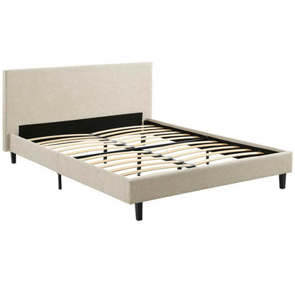 Beige fabric upholstered platform bed with tall headboard, slatted base and black tapered legs.