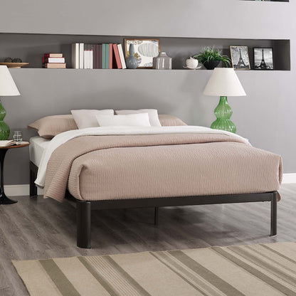 Taupe quilted duvet on a low brown bed frame with white pillows; green glass lamps, built-in shelf and striped rug.