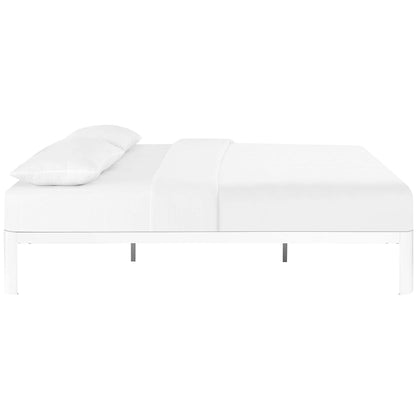White modern platform bed with a low frame & clean lines, dressed in white sheets & a pillow