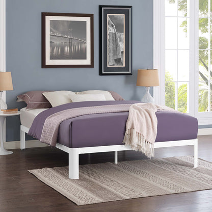 White full bed frame with lavender bedding and a beige throw in a modern blue-walled room with black-framed wall art.